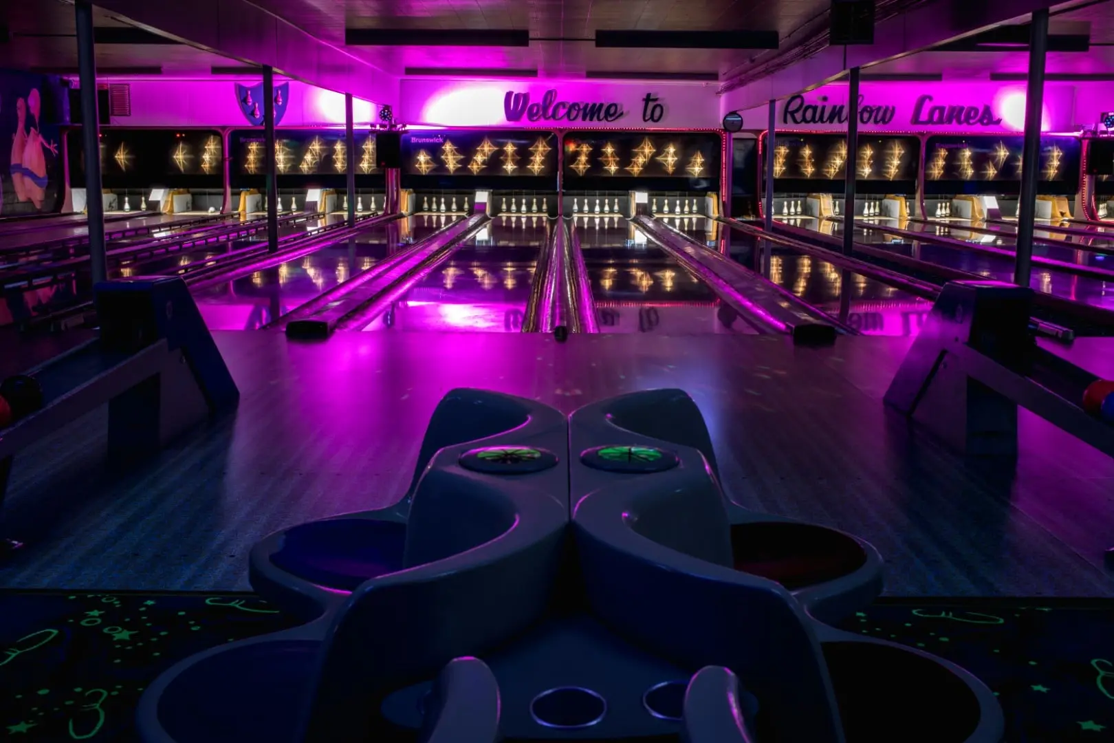 The approach and lanes washed in magenta light during glow bowling.